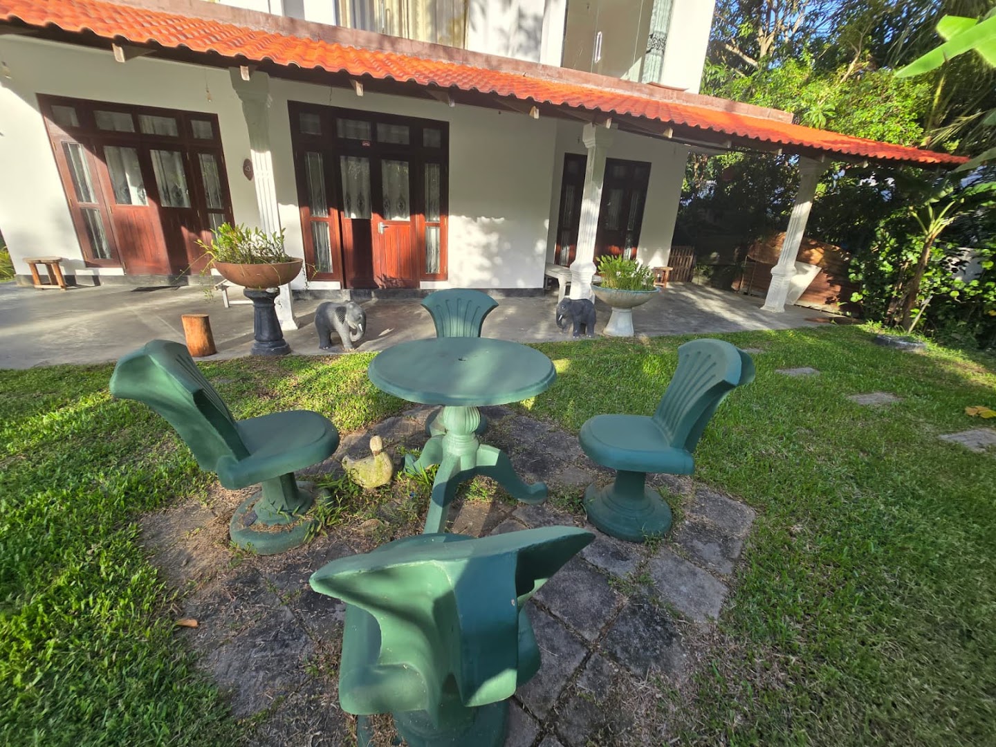 Outdoor seating on the villa lawn in front of the covered veranda
